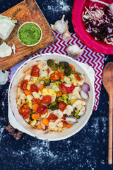 Baked, roasted, grilled vegetables on iron cast skillet with herbs and spices. Tomato, broccoli, cauliflower, potato, mushrooms, onion. Vegetarian dinner, vegan lunch, healthy food. Top above view.