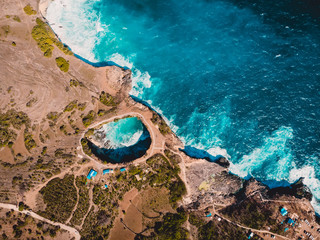 Broken bay in Nusa Penida Island. Aerial drone view with rocky shore and blue ocean