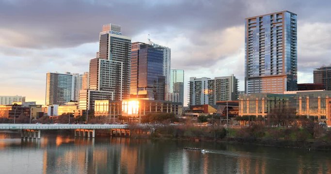 Sculling row boat sunset river Austin Texas skyline. Row Race team practice. Brilliant sunset colors. Lady Bird Lake,  Town Lake is a river reservoir on Colorado River in Austin, Texas. 