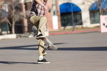 Fototapeta premium Person riding a skate board in an urban asphalt park