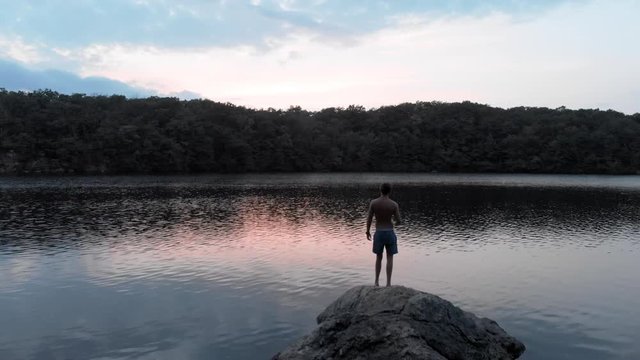 Aerial: Lake and a Man Standing on Rock
