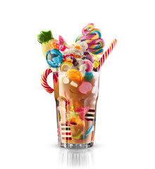 Monster shake, freak caramel shake isolated. Colourful, festive milk shake cocktail with sweets, jelly. Colored caramel milkshake array of different childs sweets and treats in glass on white