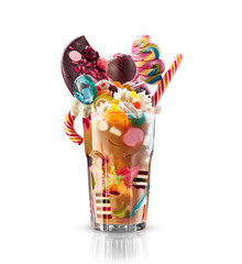 Monster shake, freak caramel shake isolated. Colourful, festive milk shake cocktail with sweets, jelly. Colored caramel milkshake array of different childs sweets and treats in glass on white