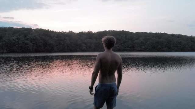 Aerial: A Man Looking at Calm Lake