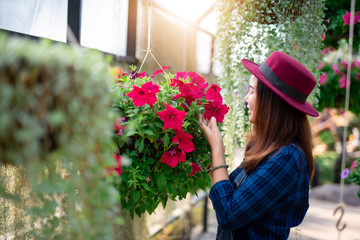 Young women and flower care in the garden that are blooming in the morning