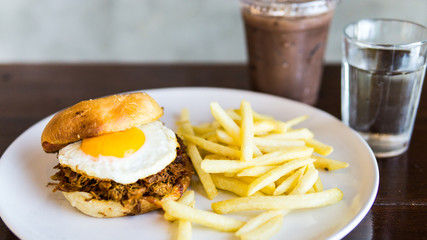 Pull Pork burger With French Fries on the white plate and ice chocolate.