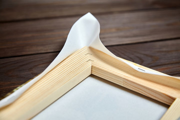 Canvas stretching on wood stretcher bar. Edge of photo printed on canvas on wooden table