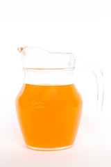 Glass jug of orange soda isolated on white background