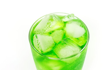 Summer drink; green soda on ice in glass isolated on white background