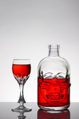 A skull bottle and crystal glasses with a liquid, alcohol drink.