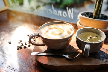 Cappuccino coffee in white cup and cup of tea lay on wooden table,Relax time with coffee,Art of coffee