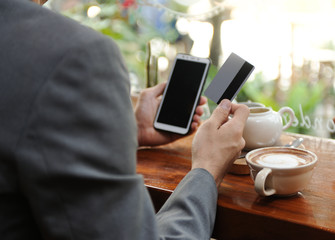 Business man using smartphone for shopping online while  drinking some coffee,Business man using net banking in smartphone,Business and investment online,Social network,Selective focus