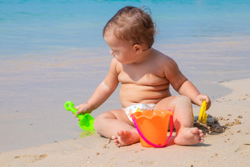 Happy child playing in summer on the blue sea