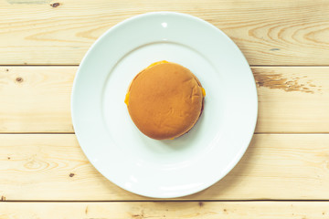 plain burger on white plate and wooden table