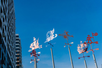 Iron Weathervanes in the Background of the Blue Sky and a New Building