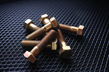 Some anodized bolts on a black background