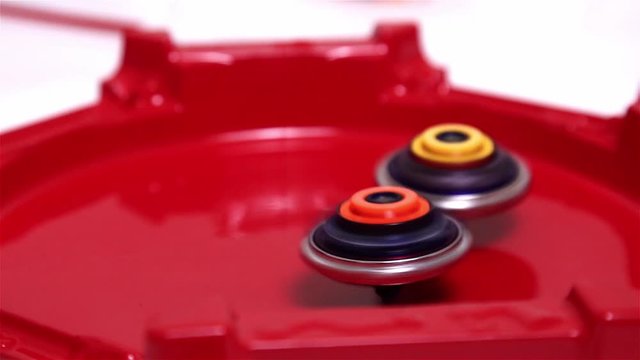 Popular Modern Children Game Beyblade Burst Fast spinning on red arena.