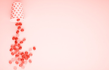 Candy scattered on the background. Top view. Living coral is the primary color of the year. The main concept trend. Photo tinted