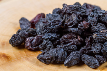 Blue raisins on a wooden background