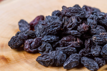 Blue raisins on a wooden background