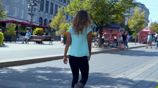 Slow Motion: Young Woman Walking Down a Pedestrian Street on a Sunny Day