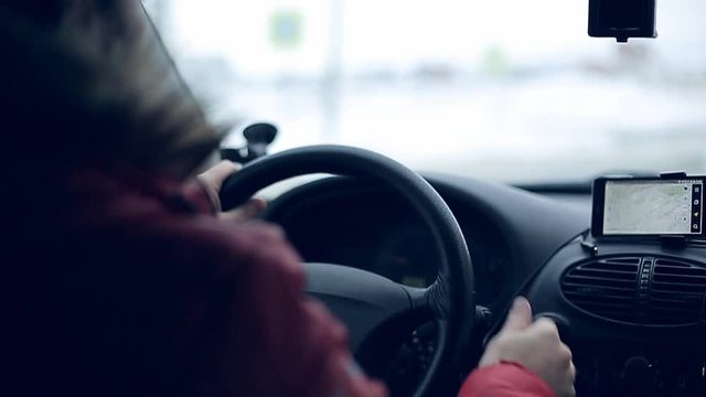 A man gets into the car and turns on the navigator on the smartphone