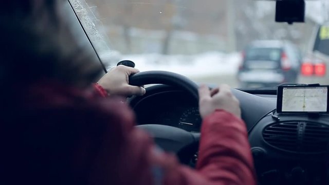 A man gets into the car and turns on the navigator on the smartphone
