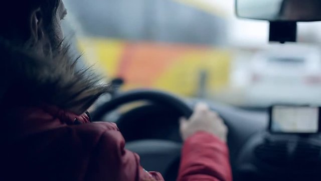A man gets into the car and turns on the navigator on the smartphone