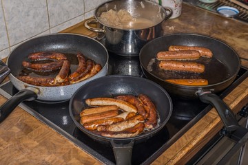 Kalbsbratwürse und Schweinebratwürste und vegetarische Bratwürste in Bratpfannen und Sauerkraut, Deutschland