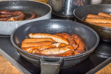 Kalbsbratwürse und Schweinebratwürste und vegetarische Bratwürste in Bratpfannen und Sauerkraut, Deutschland