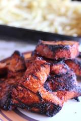 Grilled meat and french fries in the background