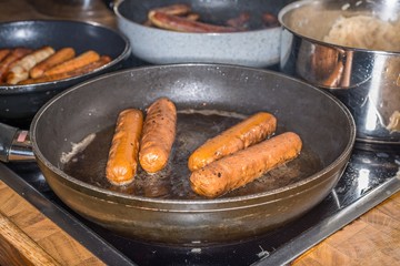 Kalbsbratwürse und Schweinebratwürste und vegetarische Bratwürste in Bratpfannen und Sauerkraut, Deutschland