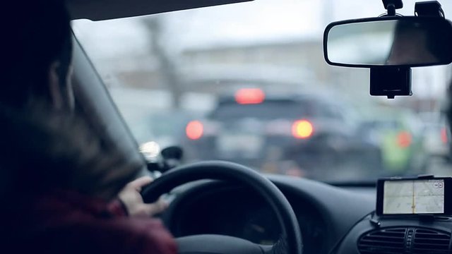 A man gets into the car and turns on the navigator on the smartphone