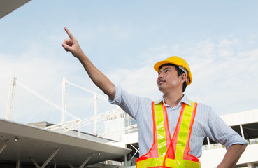 Engineer is pointing the job,Engineer is setting goal,Engineer is controlling the construction on site background,Selective focus