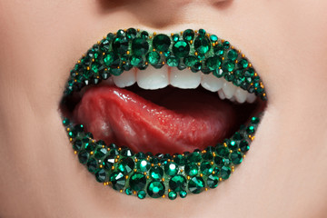 Grüne Lippen mit Strasssteinen bedeckt. Schöne Frau mit grünem Lippenstift auf den Lippen