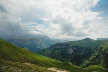 Naklejka premium Dramatic landscape of a green valley at the foot of the Inal Plateau in the North Caucasus