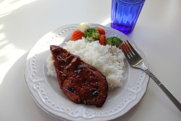 A plate with rice and chicken teriyaki