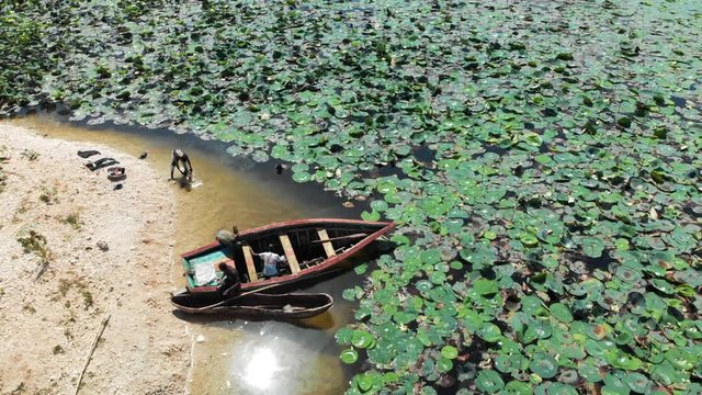 Aerial View Men & a Boat on the Shore of Lake Azuei