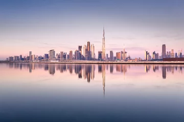 Fotobehang Dubai Mooie kleurrijke zonsopgang die de skyline en de weerspiegeling van Dubai Downtown verlicht. Dubai, Verenigde Arabische Emiraten.