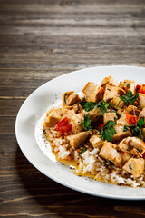 Grilled meat, white rice and vegetables on wooden table