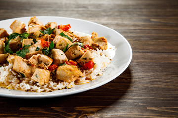 Grilled meat, white rice and vegetables on wooden table