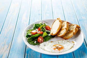 Breakfast - fried egg, toasts and vegetable salad