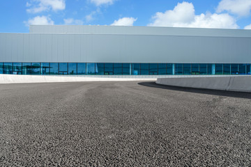 Fototapeta na wymiar Road asphalt pavement and modern factory warehouse..