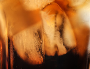 Glass of tasty refreshing cola with ice cubes, closeup