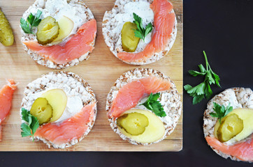 Sandwiches with cottage cheese, red fish, ginger and pickled cucumber on a cereal loaf