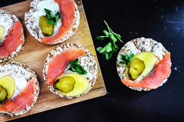 Sandwiches with cottage cheese, red fish, ginger and pickled cucumber on a cereal loaf