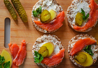 Sandwiches with cottage cheese, red fish, ginger and pickled cucumber on a cereal loaf