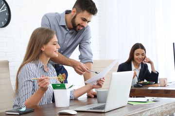 Obraz premium Office employees having lunch at workplace. Food delivery