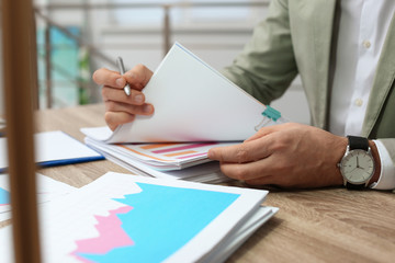 Businessman working with documents at office table, closeup