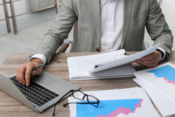 Businessman working with documents at office table, closeup